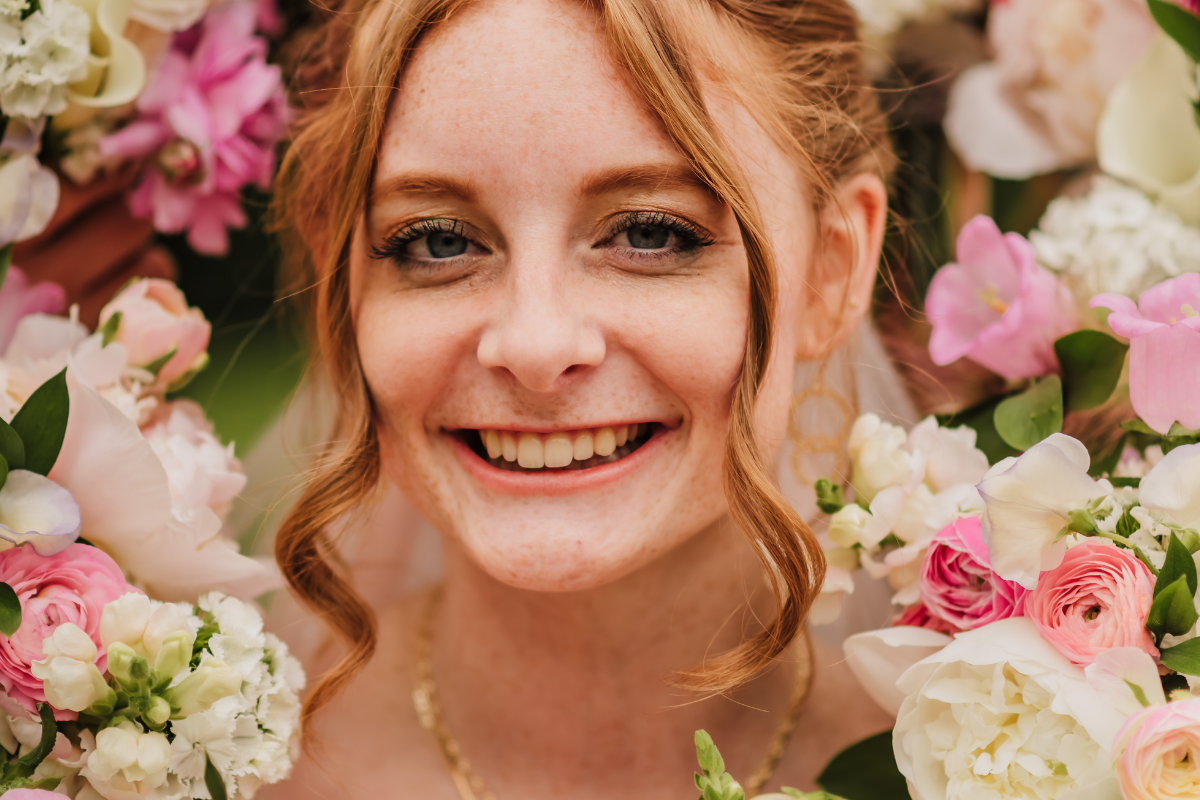 close up of face smiling surrounded by flowers